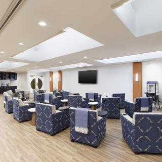 A modern waiting room with comfortable seating and a television.