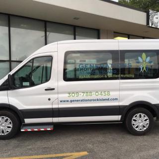 A white passenger van parked outside a building, displaying business contact information and advertising on its side.