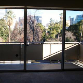 A glimpse of the city through a spacious balcony with large glass windows.