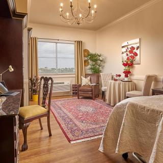 A cozy living room with elegant furnishings, a chandelier, and a large window.
