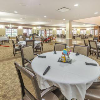 A spacious dining room with neatly arranged tables and chairs, ready for guests.