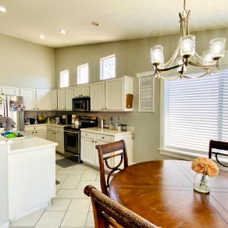 A spacious and modern kitchen featuring a dining area with elegant lighting.