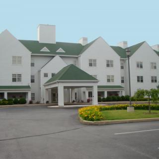 A hotel building with a green roof and landscaped entrance.