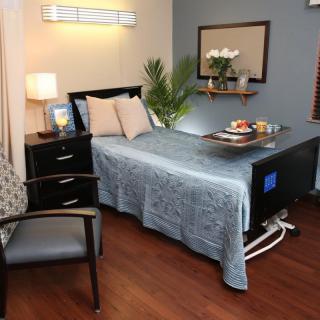 A well-decorated hospital room with a comfortable bed and bedside amenities.