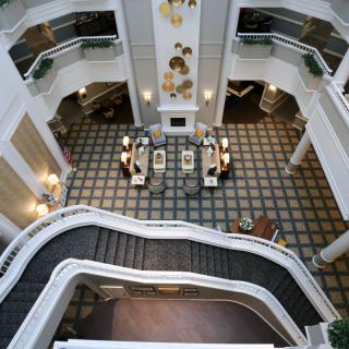An elegant atrium with a grand staircase in a hotel lobby.