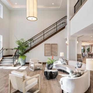 A spacious and modern living room with a sleek staircase and minimalist decor.
