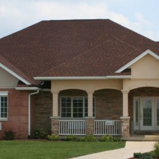 A suburban residential house with a large roof and front porch.