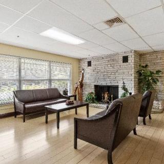 A cozy living room with a brick fireplace, sofas, and a coffee table.