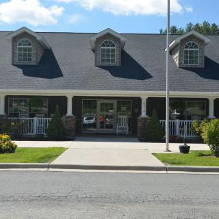 A storefront with a symmetrical facade and a well-maintained lawn.