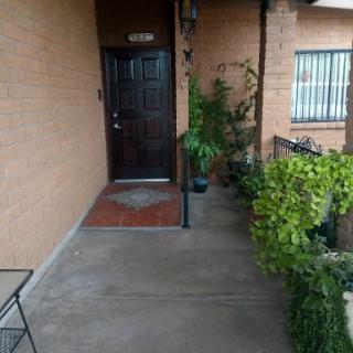 A welcoming entrance to an apartment, featuring a door and surrounding greenery.