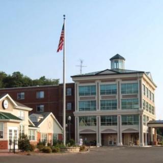 A multi-story commercial building with an American flag flying in front.