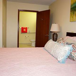 A cozy bedroom with a view into an adjoining bathroom.