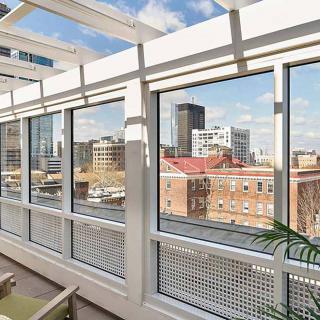 A bright urban cityscape view from a glass-enclosed space on a sunny day.