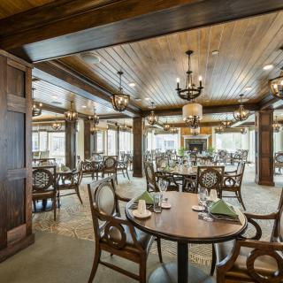 An elegant dining room with wooden interiors and chandeliers.