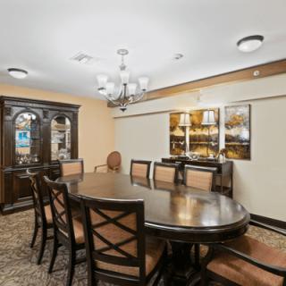 A traditional dining room with a large table, chairs, and a chandelier.