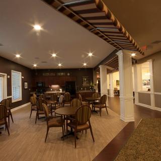 A cozy cafe interior with tables and chairs arranged under warm lighting.