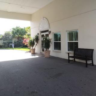 A welcoming entrance with outdoor seating and lush greenery.
