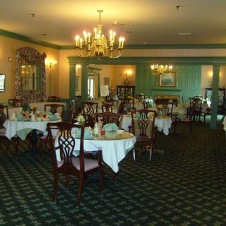 An elegant restaurant dining room with neatly set tables and a chandelier.