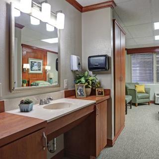 A modern bathroom interior featuring a well-lit vanity area with mirror and sink.