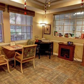A cozy office interior with chairs and tables near large windows.