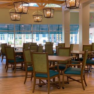 A spacious dining area with elegant lighting and large windows.