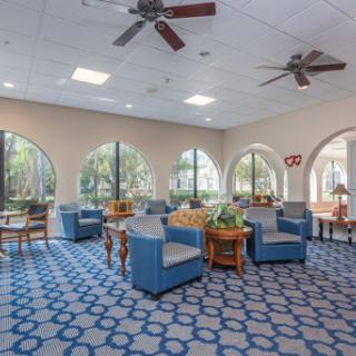 A cozy lounge area featuring blue upholstered furniture and ample natural light.