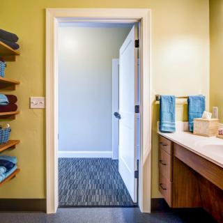 A well-organized bathroom with neatly stacked towels and an open door.