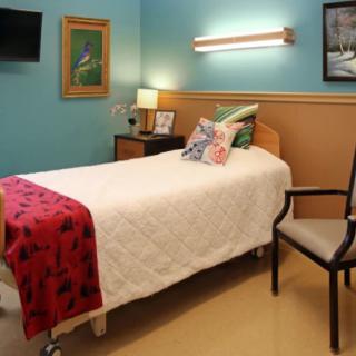 A neatly arranged hospital room with a single bed and colorful decor.