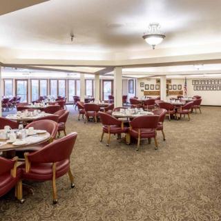An empty dining room with neatly arranged tables and chairs, ready for guests.