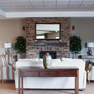 A cozy living room with a central fireplace and comfortable seating.