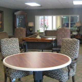 A comfortable lounge area with a round table and patterned chairs.