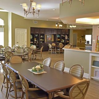 A cozy dining room with multiple tables and chairs, featuring warm lighting and elegant decor.
