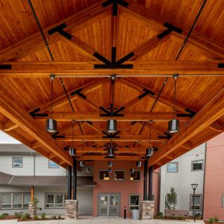 A modern building entrance with an intricately designed wooden ceiling.