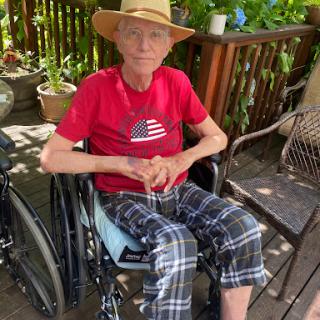An individual comfortably seated in a wheelchair, enjoying the outdoors.