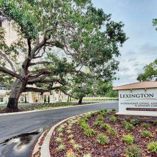 Entrance to a complex with landscaped surroundings and prominent signage.