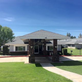 A charming residential building with a well-maintained lawn under a clear blue sky.