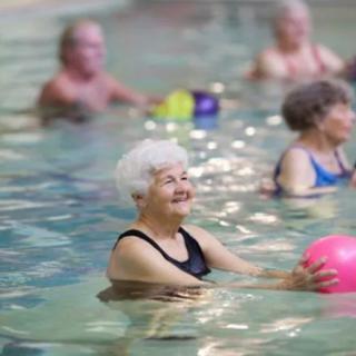 Senior citizens enjoying a water exercise class in a swimming pool.
