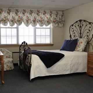 A cozy bedroom with a single bed and decorative furnishings.