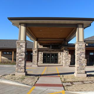 A modern building entrance featuring stone pillars and a spacious overhang.