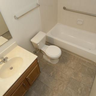 A clean bathroom with a toilet, sink, and bathtub.