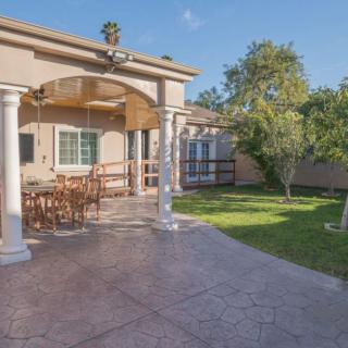 A spacious backyard patio with outdoor furniture and a well-maintained garden.