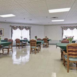 A well-lit dining room with several tables and chairs arranged neatly.