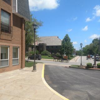 A sunny day showcasing a street view with buildings, trees, and a clear blue sky.