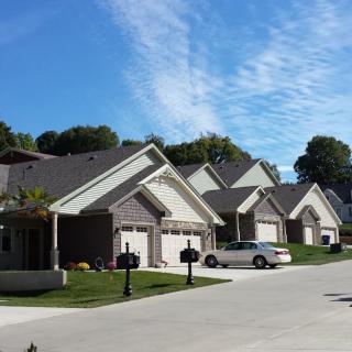 A sunny suburban neighborhood with multiple houses and a clear blue sky.