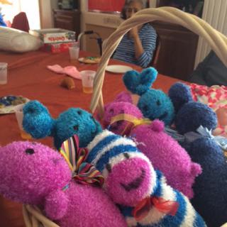 A cheerful collection of handmade knitted toys in vibrant colors, displayed in a basket.