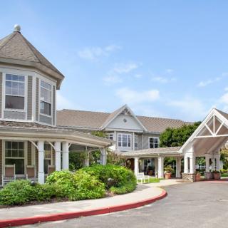 A charming residential building with a well-maintained garden and a covered entrance.