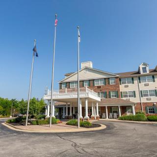 A hotel entrance with flags and a clear blue sky.