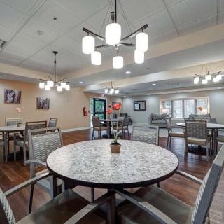 A modern dining room with elegant lighting and neatly arranged tables and chairs.
