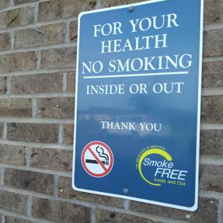 A sign indicating a no smoking policy for the health of all individuals, applicable both inside and outside.
