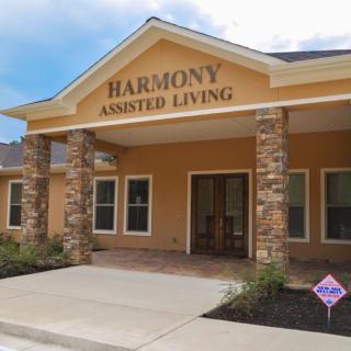 The entrance of Harmony Assisted Living facility, featuring a welcoming design with stone pillars and a well-maintained exterior.